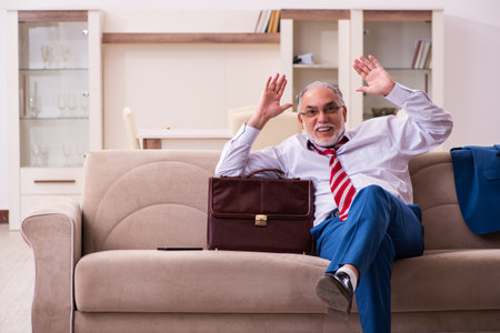 Old male boss employee coming home from workの写真素材