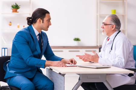 Young businessman meeting with old doctorの写真素材