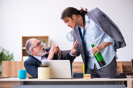 Old boss and male alcoholic employee in the officeの写真素材