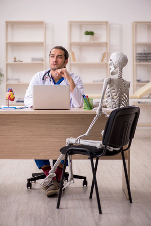 Young male doctor and skeleton patient in the clinicの写真素材