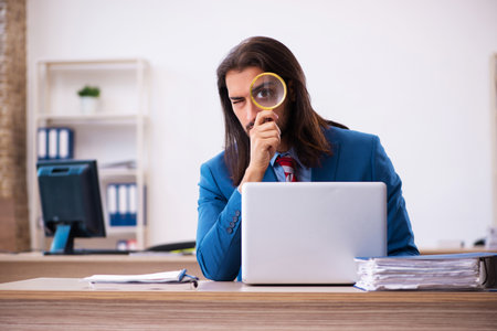 Young male employee working at workplaceの写真素材