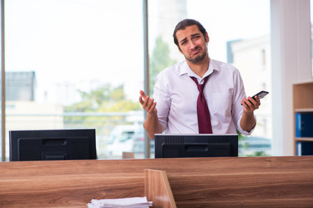 Young male employee and too many work in the officeの写真素材