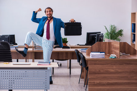 Young male employee coming to work straight from bedの写真素材