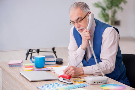 Old male designer working in the officeの写真素材