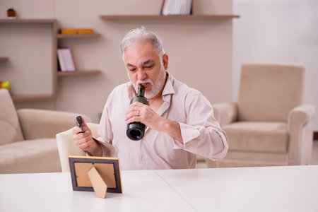 Old male alcoholic widower committing suicide at homeの写真素材