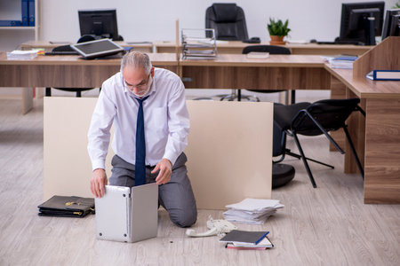 Old businessman employee in bankruptcy concept in the officeの写真素材