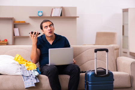 Young man preparing for journey at homeの写真素材