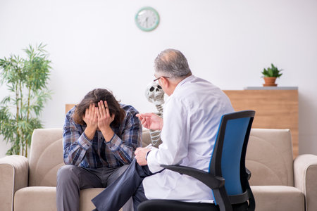 Young male patient visiting experienced doctor psychiatristの写真素材