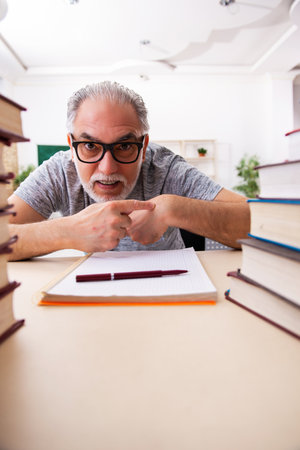 Old male student preparing for exams in the classroomの写真素材