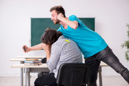 Two male pupils in bullying concept in the classroomの写真素材