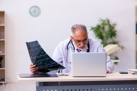 Old male doctor radiologist working in the clinicの写真素材