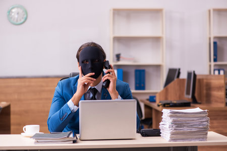 Young male employee wearing masks in the officeの写真素材