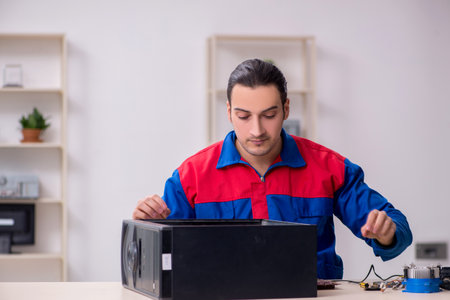 Young male repairman repairing computerの写真素材