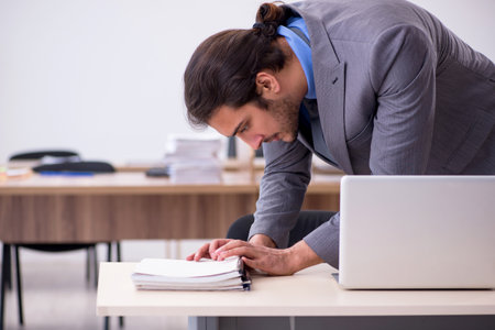 Young male employee in industrial espionage conceptの写真素材