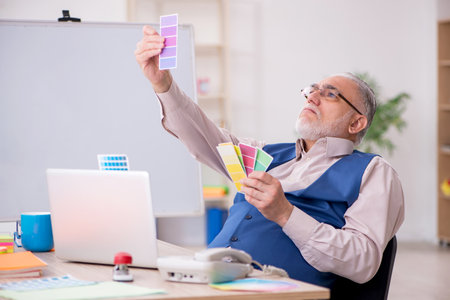 Old male designer working in the officeの写真素材