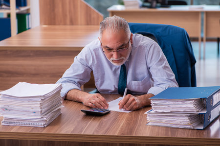 Old male employee working in the officeの写真素材
