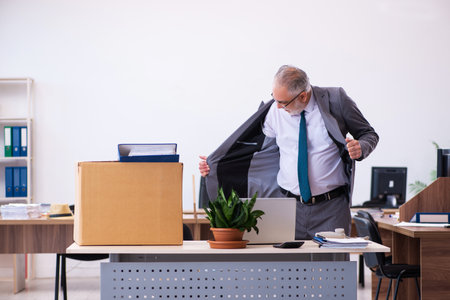 Old male employee being fired from his workの写真素材