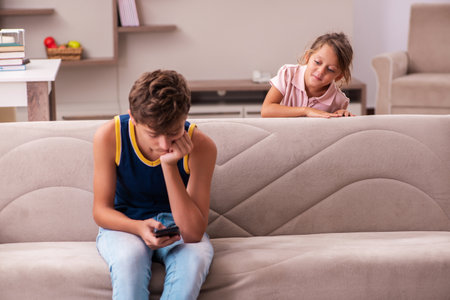Boy and his small sister staying at home during pandemicの写真素材