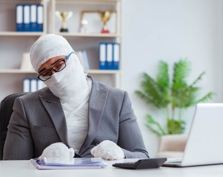 Bandaged businessman worker working in the office doing paperworの写真素材