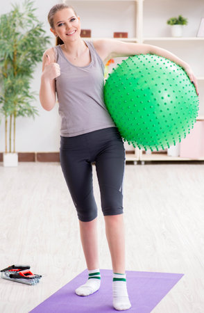 Young woman exercising with stability ball in gymの写真素材