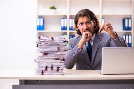 Young male employee and too many cockroaches in the officeの写真素材