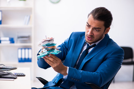 Young male accountant in budget planning conceptの写真素材
