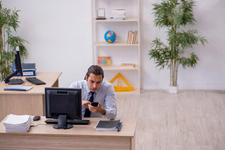 Young male employee sitting in the officeの写真素材