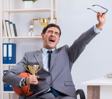 Businessman with prize cup for achievements in officeの写真素材