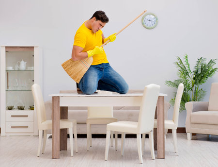Funny man playing virtual guitar with broomの写真素材