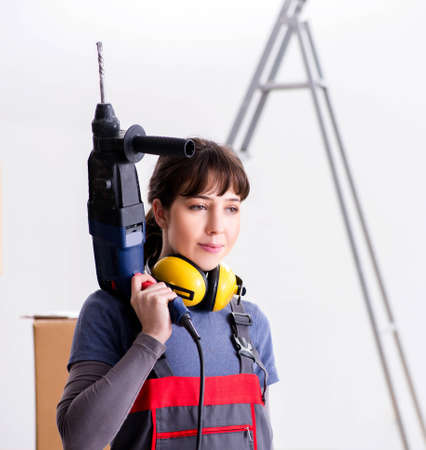 Woman contractor with hand drill at construction siteの写真素材