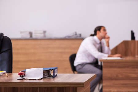 Young male employee stapling paper in the officeの写真素材