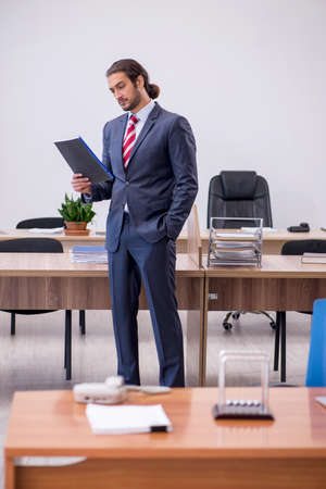 Young man businessman employee sitting in the officeの写真素材