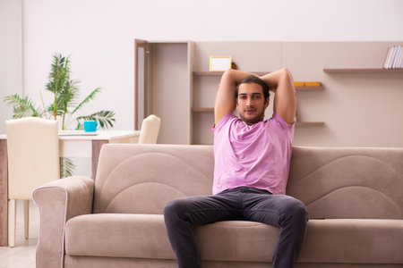 Young man staying at home during pandemicの写真素材