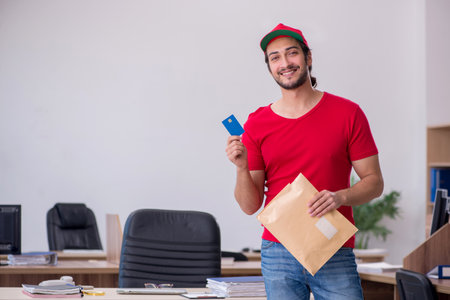 Young male courier delivering post to the office