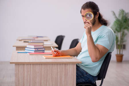 Young male student in the classroom during pandemicの写真素材