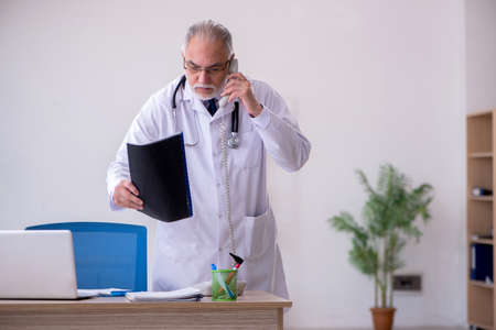 Old male doctor in telemedicine conceptの写真素材