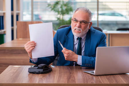 Old male employee working in the officeの写真素材