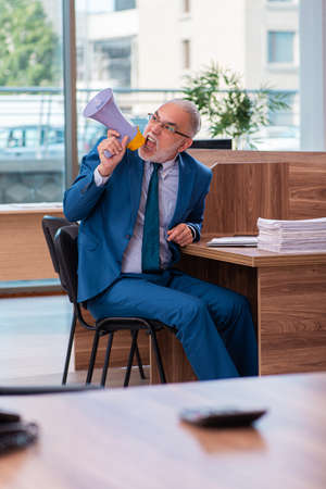 Old male employee working in the officeの写真素材