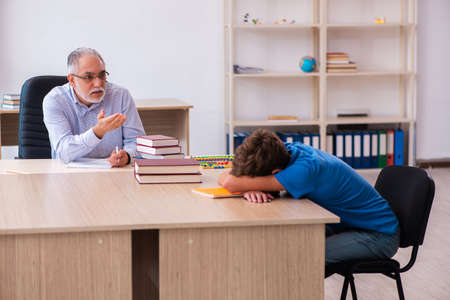 Old male teacher and schoolboy in the classroomの写真素材