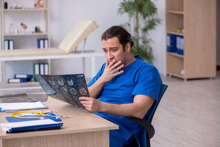 Young male doctor radiologist being unhappy after night shift