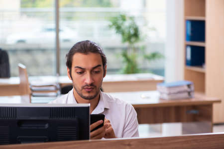Young male employee and too many work in the office