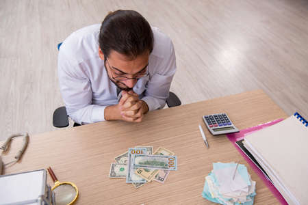 Young male bookkeeper in budget planning concept