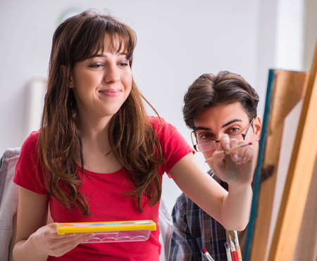 Artist coaching student in painting class in studioの写真素材