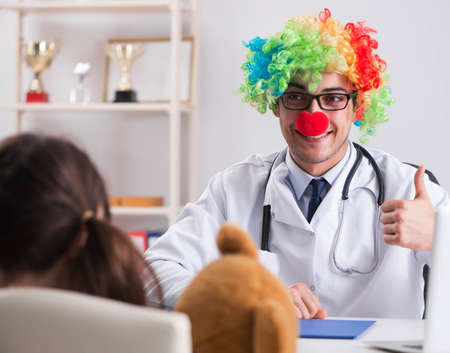 Funny pediatrician with little girl at regular check-upの写真素材