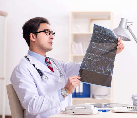 Young handsome doctor working in hospital roomの写真素材