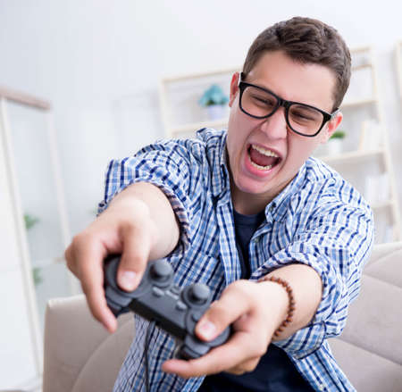 Young man playing computer games at home