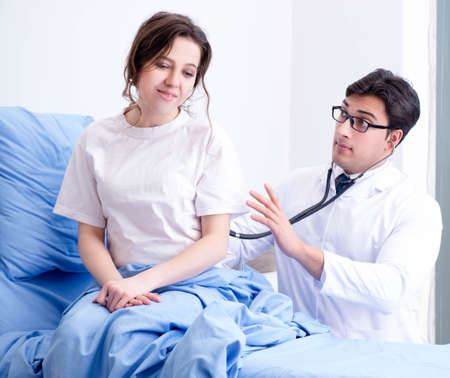Doctor visiting patient in hospital roomの写真素材