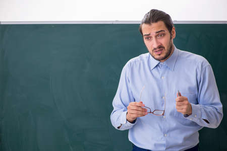 Young underpaid male teacher in the classroomの写真素材