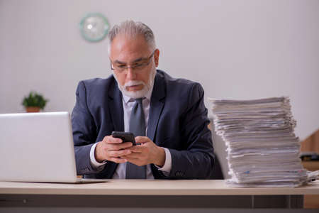 Old male employee unhappy with excessive work in the office