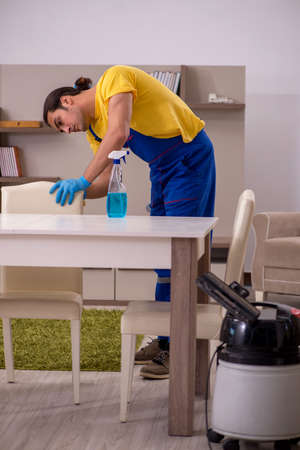 Young male contractor cleaning the houseの写真素材